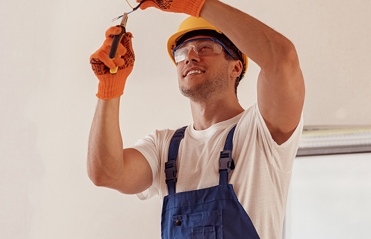 cheerful-electrician-repairing-electric-cable-ceiling (1)